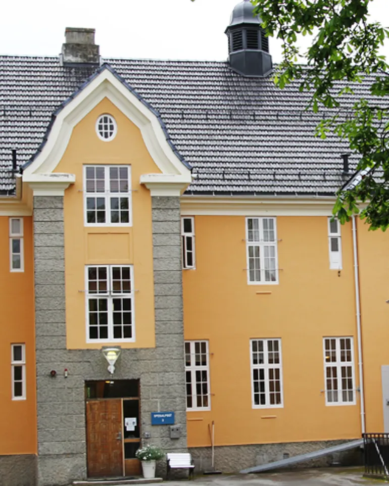 En bygning med et tre foran
